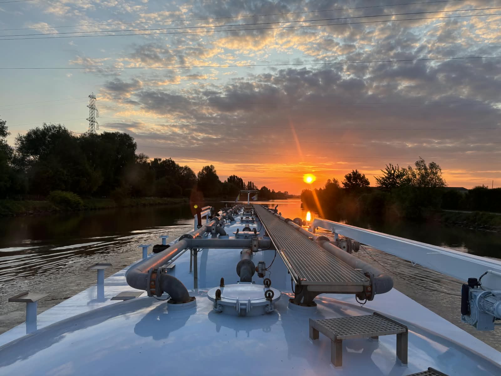 Uitzicht over een binnenvaartschip tijdens zonsondergang
